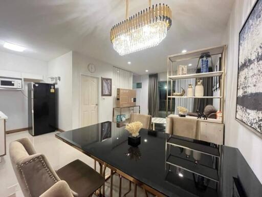 Modern dining area with an elegant chandelier and a black dining table