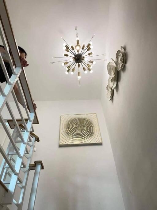 Modern staircase with artwork and chandelier