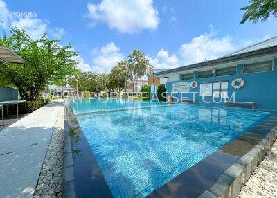 Swimming pool area with trees and a building in the background