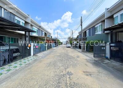 A view of a residential street with modern townhouses