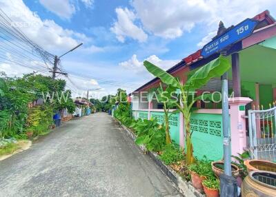 Exterior of a residential building with a green fence and street view