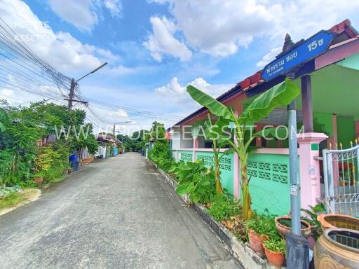 Exterior of a residential building with a green fence and street view