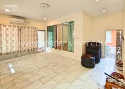 Spacious living room with large window and tiled floor