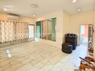 Spacious living room with large window and tiled floor