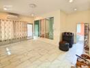 Spacious living room with large window and tiled floor