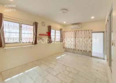 Bright living room with large windows, air conditioning, and tiled floors.