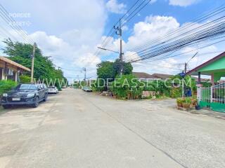 Street view of a neighborhood with houses and cars parked on the side