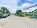 Street view of a neighborhood with houses and cars parked on the side