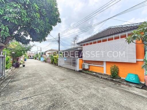 Street view of residential building with vibrant orange exterior and driveway