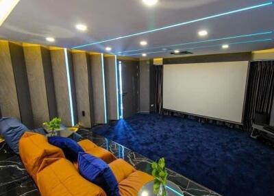 Spacious entertainment room with theater setup and comfortable seating