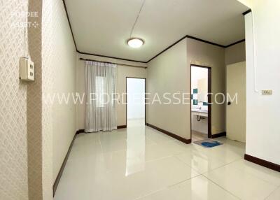 Clean and modern living area with tiled floor and adjacent bathroom