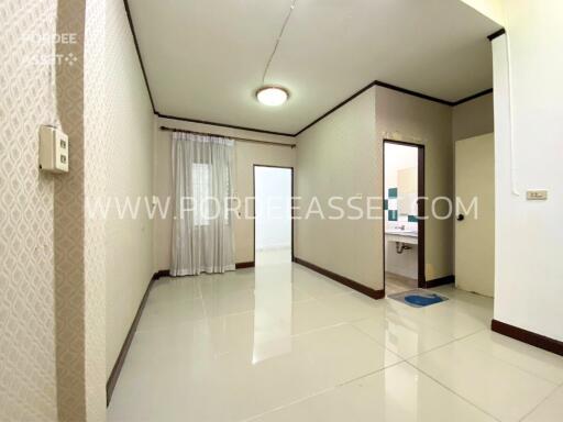 Clean and modern living area with tiled floor and adjacent bathroom