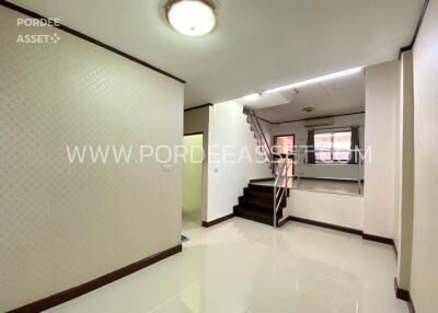 Main living area with staircase and white ceramic tiles