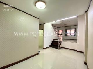 Main living area with staircase and white ceramic tiles