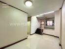 Main living area with staircase and white ceramic tiles