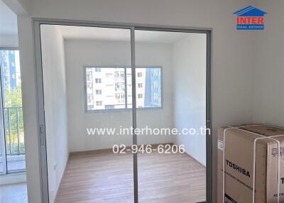 Bedroom with large window and wooden flooring.