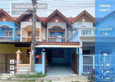 Exterior view of a townhouse with blue and white paint and gated driveway