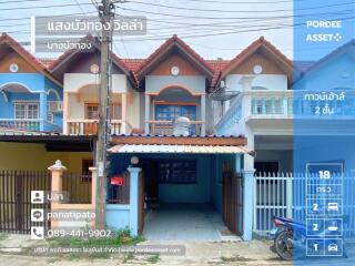 Exterior view of a townhouse with blue and white paint and gated driveway