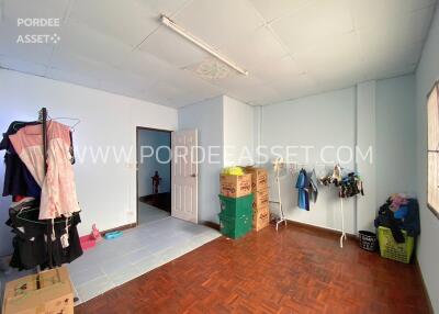 Bedroom with wooden flooring and open storage boxes