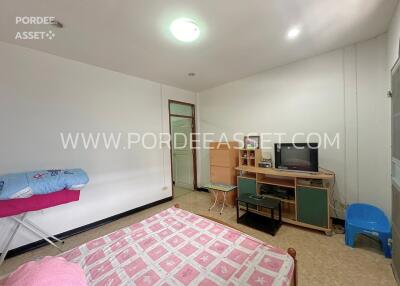 Bedroom with simple furnishing and ironing board