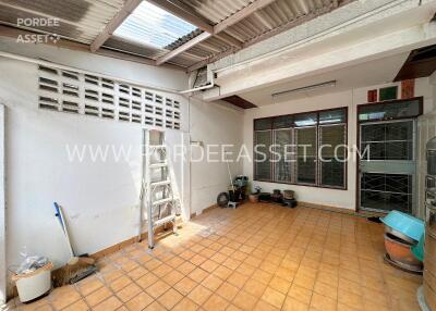 Indoor utility area with tiled floor and open roofing