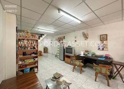 Spacious living area with office desk, TV, and staircase