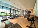 Modern gym with various fitness equipment and large windows