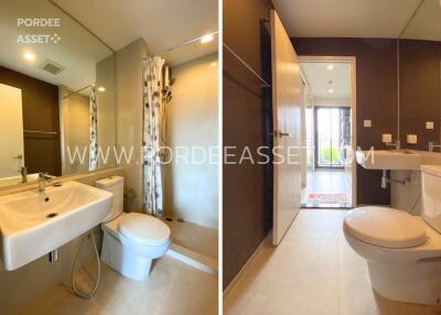 Modern bathroom with white fixtures, large mirror, and shower area with curtain