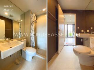 Modern bathroom with white fixtures, large mirror, and shower area with curtain