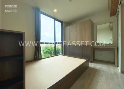 Bedroom with large windows and wooden furniture