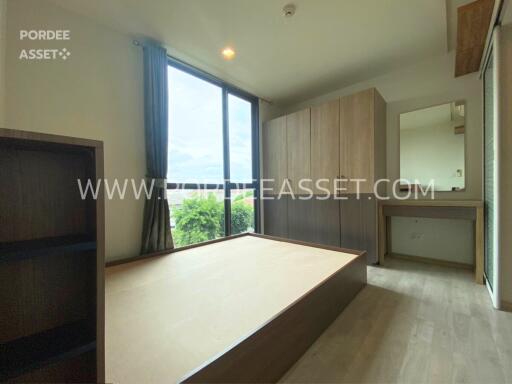 Bedroom with large windows and wooden furniture