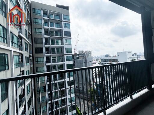 View from the balcony overlooking nearby buildings and distant cityscape