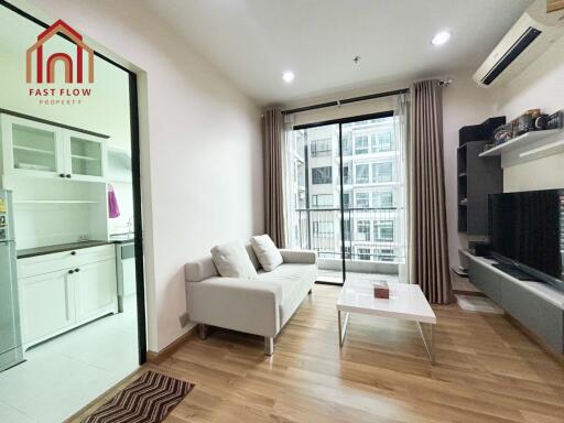 Modern living room with adjacent kitchen and large window