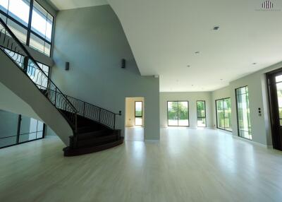 Spacious open-plan living area with modern staircase and large windows