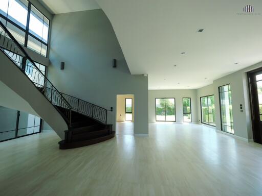 Spacious open-plan living area with modern staircase and large windows