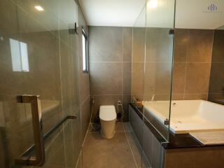 Modern bathroom with glass-enclosed shower and tiled walls