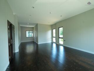 Spacious main living area with large windows and dark wooden floors