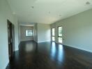 Spacious main living area with large windows and dark wooden floors