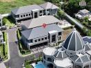 Aerial view of a modern residential complex with a central domed building and multiple two-story houses