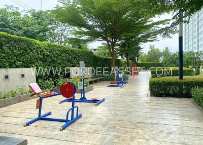 Outdoor gym area with exercise equipment and greenery