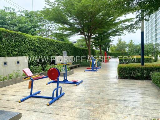 Outdoor gym area with exercise equipment and greenery