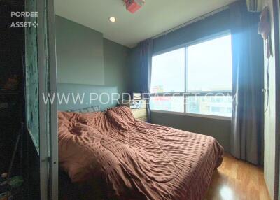 Bedroom with large window and brown bedding