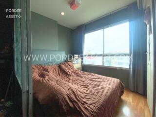 Bedroom with large window and brown bedding