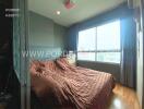 Bedroom with large window and brown bedding