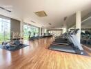 Fully-equipped gym with modern exercise machines and wooden flooring