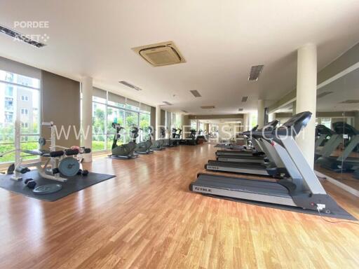 Fully-equipped gym with modern exercise machines and wooden flooring