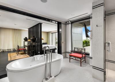 Modern bathroom with freestanding tub and view into a bedroom