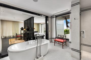 Modern bathroom with freestanding tub and view into a bedroom