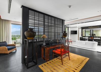 Modern living area with a view, featuring a desk, wicker chair, and bathtub