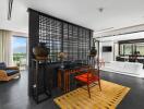 Modern living area with a view, featuring a desk, wicker chair, and bathtub